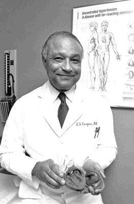 A black and white photo of Edward S. Cooper in middle age, holding a model human heart